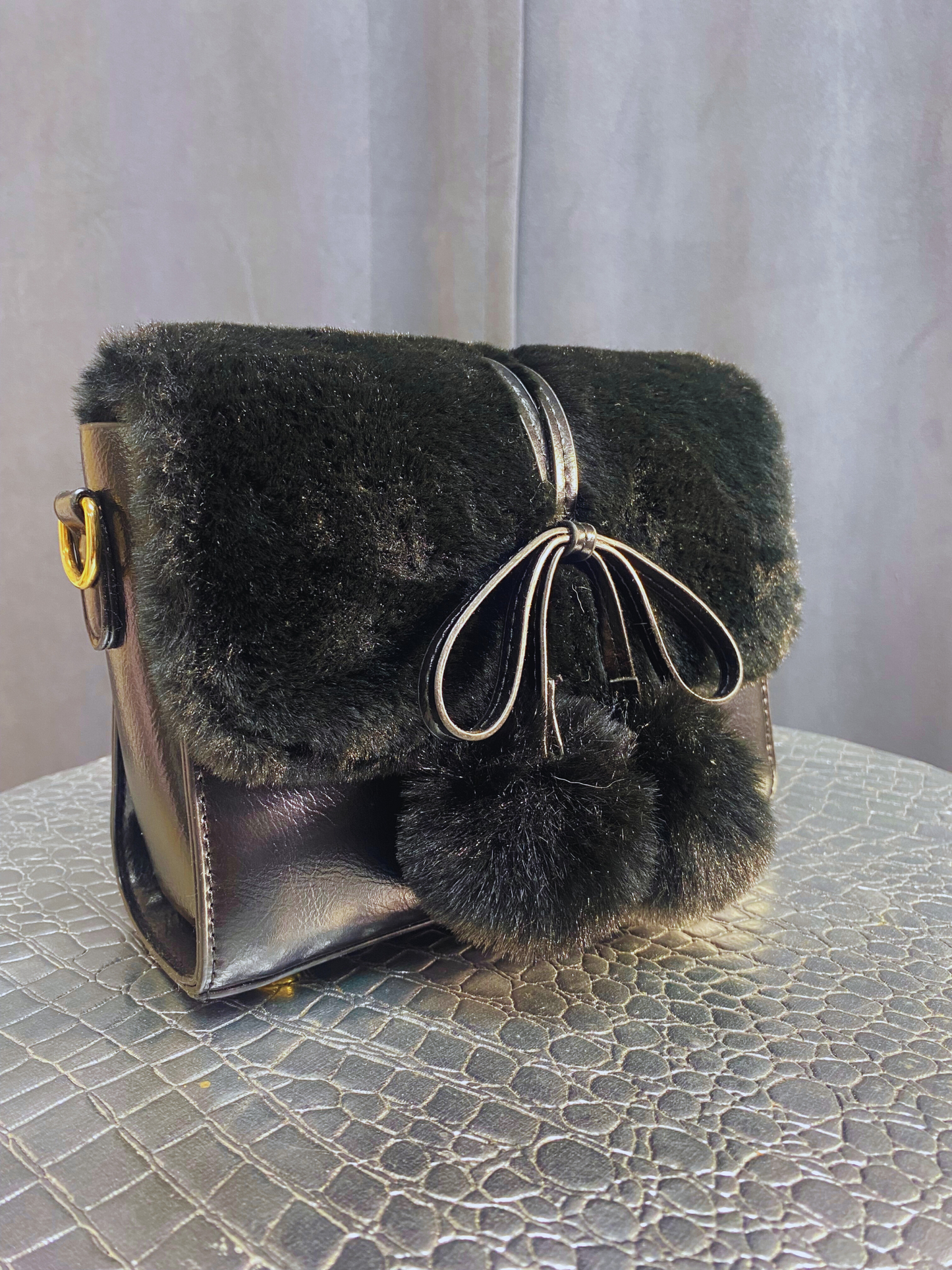 Black purse with fur, strap and gold accents