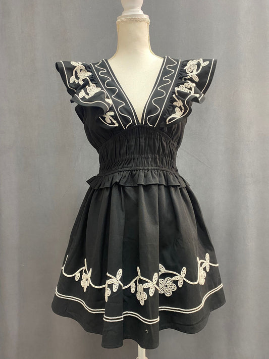 Short black and white dress featuring white floral and vine details