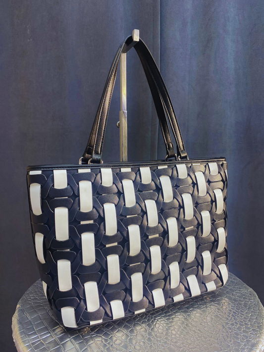 Black and white woven purse includes an additional black bag